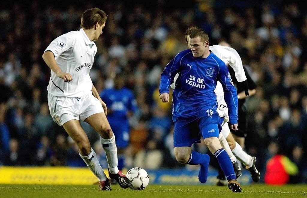 Everton's Wayne Rooney takes on Leeds' Jonathan Woodgate whilst only wearing one boot