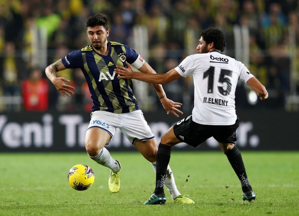 Fenerbahce's Ozan Tufan in action with Besiktas' Mohamed Elneny