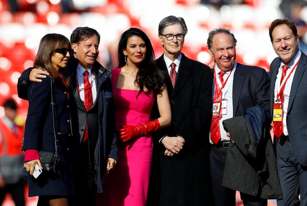 Liverpool-owner-John-W.-Henry-with-wife-Linda-Pizzuti-Henry-pose-for-a-photograph-on-the-pitch-after-the-match